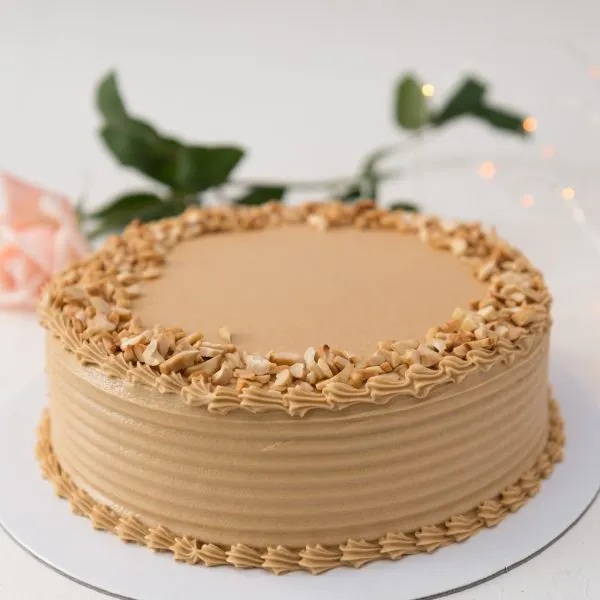 Traditional Coffee cake sandwiched and covered in coffee butter cream and topped with roasted cashew