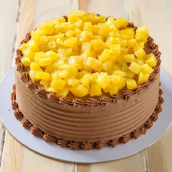 Sponge Cake sandwiched and covered in chocolate butter cream and topped with stewed pineapple
